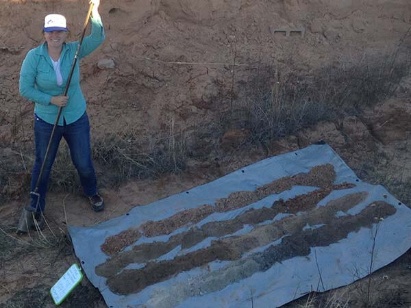Jasmine Kidwell posing with historic soil samples from the changing landscape of Blackwater Draw